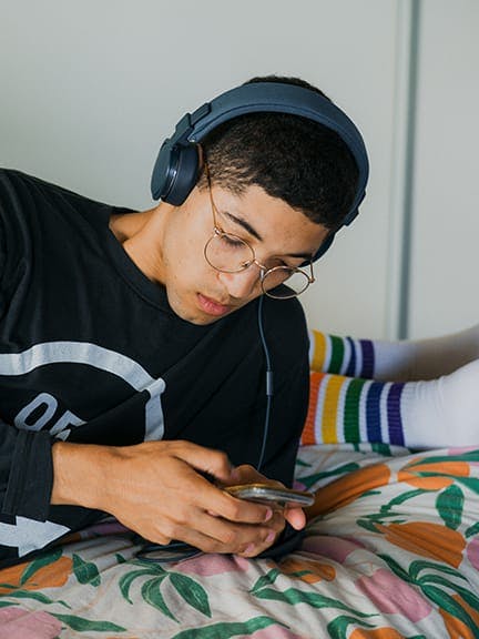 Teen listening to music on a mobile device.