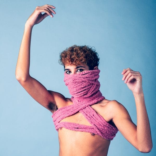 Topless young man with yarn wrapped on chest and face.