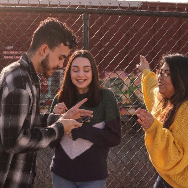 Teens looking at a cell phone