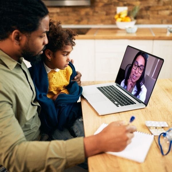 Father and a child having a telehealth conference with doctor