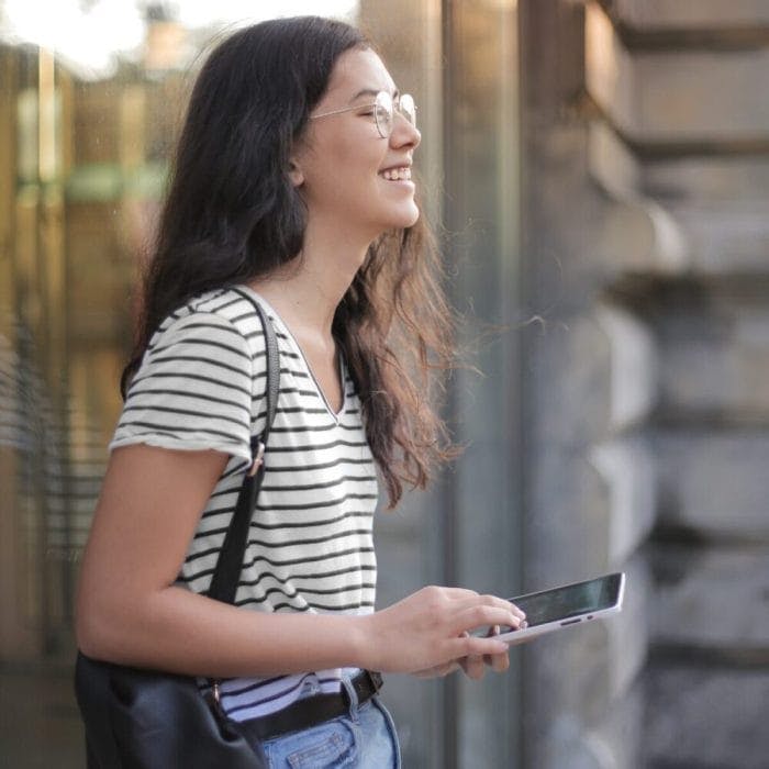Photo by Andrea Piacquadio: https://www.pexels.com/photo/cheerful-young-woman-using-smartphone-in-street-3807742/